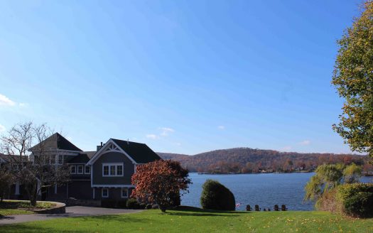 Lake home with adirondack chairs facing the water